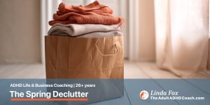 Blog post: The Spring Declutter an ADHD Brain Actually Needs — a paper bag holding neatly folded clothes ready for donation, representing considered small letting-go